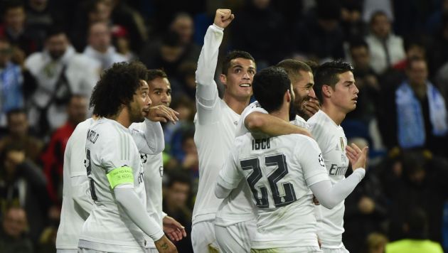 Real Madrid's Portuguese forward Cristiano Ronaldo (C) celebrates with teammates after scoring his fourth goal during the UEFA Champions League Group A football match Real Madrid CF vs Malmo FF at the Santiago Bernabeu stadium in Madrid on December 8, 2015. AFP PHOTO/ PIERRE-PHILIPPE MARCOU